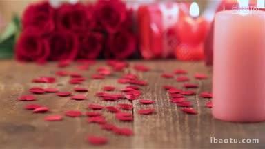 红玫瑰礼盒和蜡烛在木制背景情人节的概念